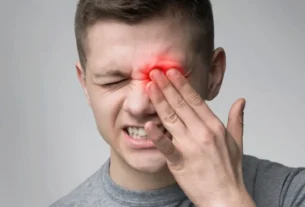 Person using a laptop experiencing digital eye strain from prolonged blue light exposure